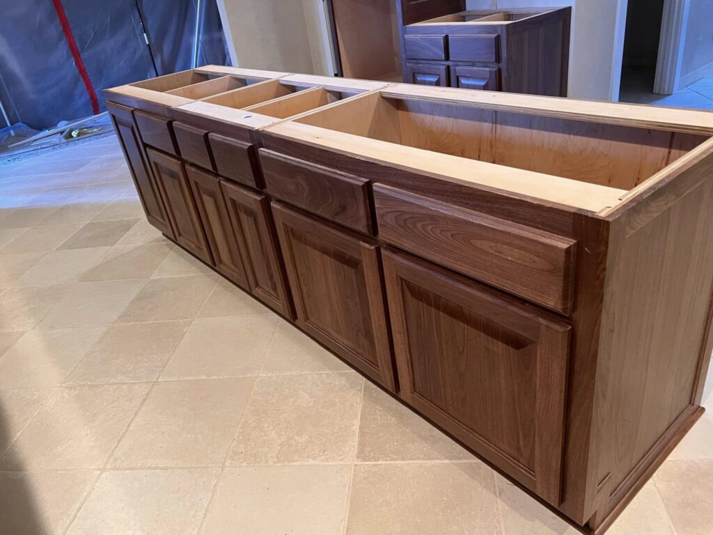 Dark-stained wood kitchen island cabinetry shown in the workshop