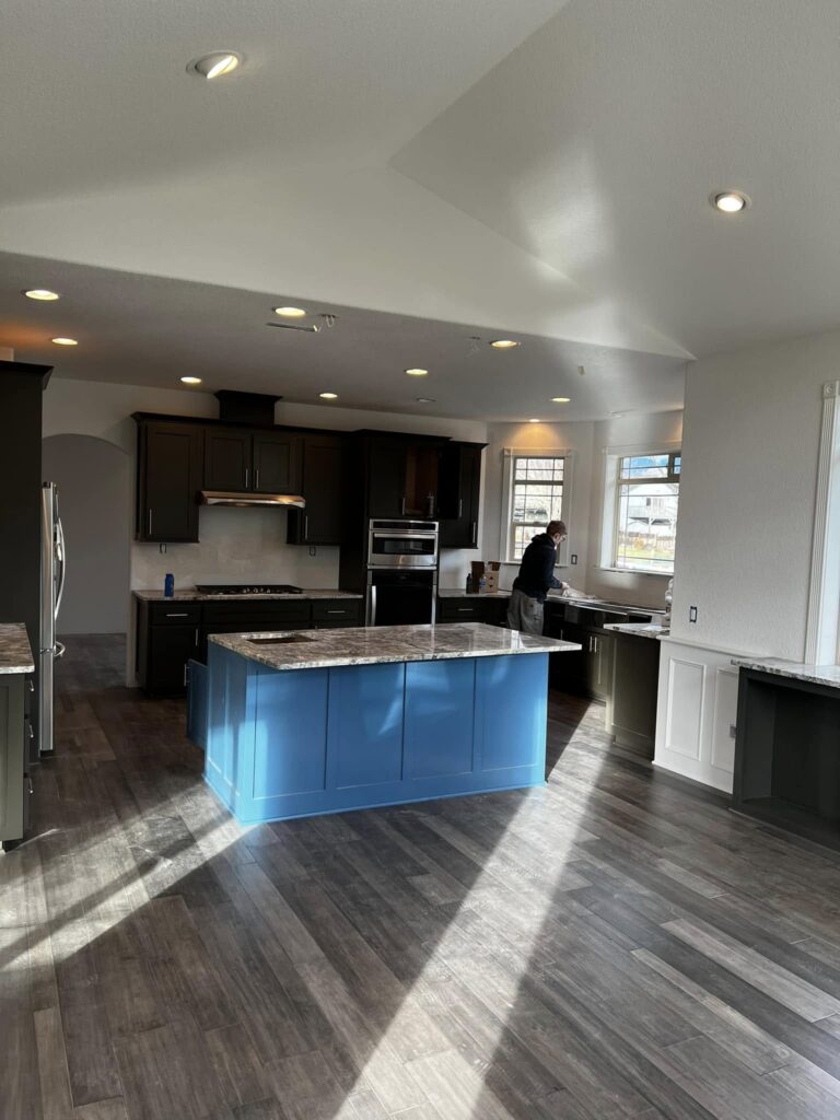 Completed kitchen with a blue island and dark perimeter cabinetry