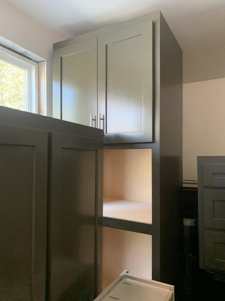 Tall gray cabinetry with an open appliance or storage niche