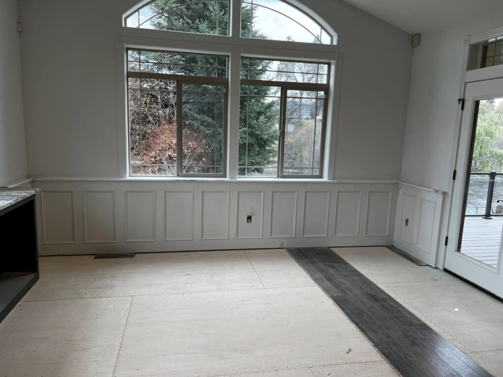 Bright room with custom white wall paneling and built-in trim