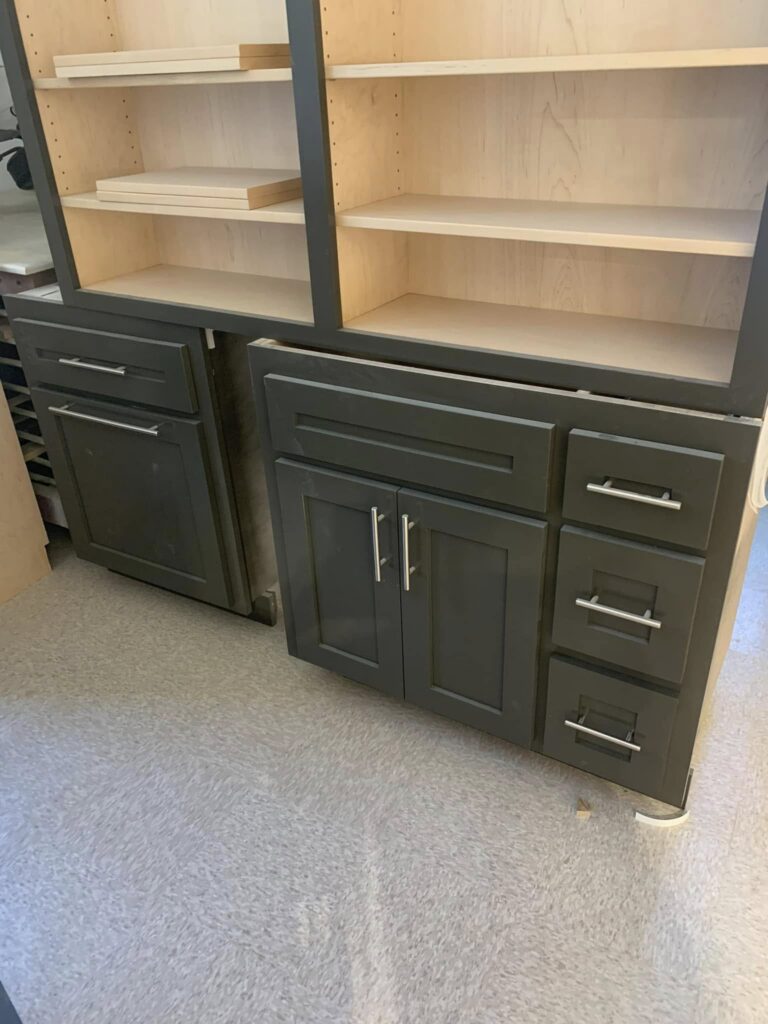 Gray base cabinets with natural-wood open shelving in the workshop