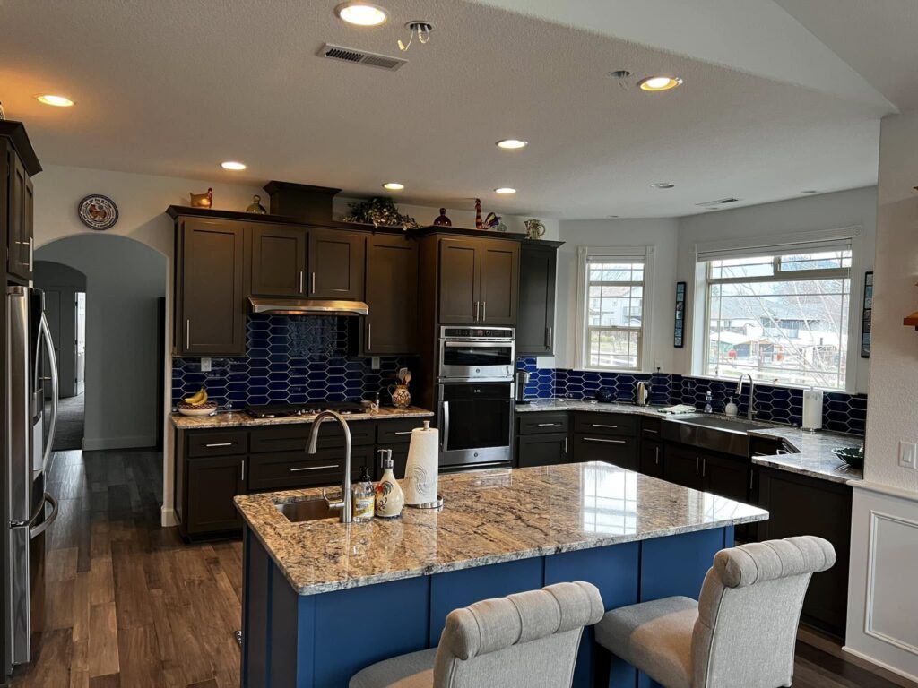 Finished kitchen with blue island viewed from the dining area