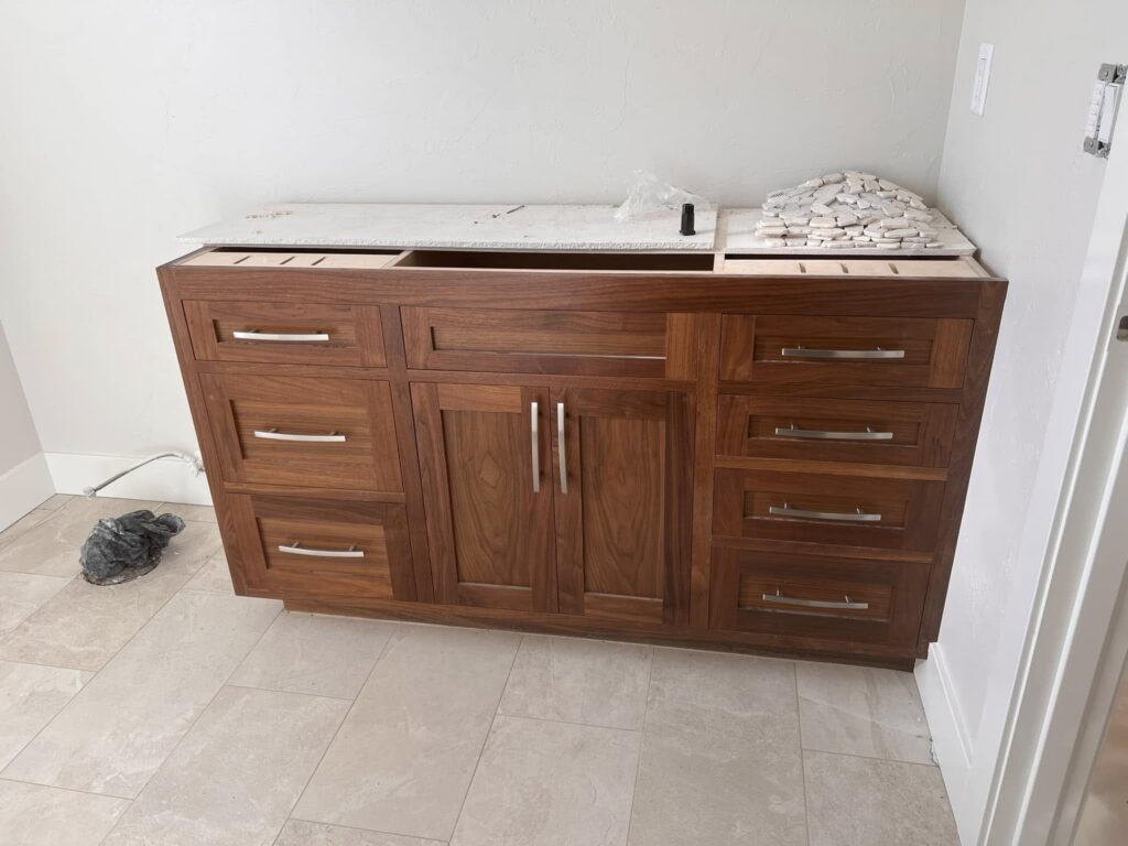 Walnut bathroom vanity with multiple drawers and cabinet doors