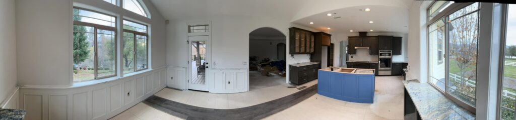 Panoramic view showing the blue-island kitchen and paneled room