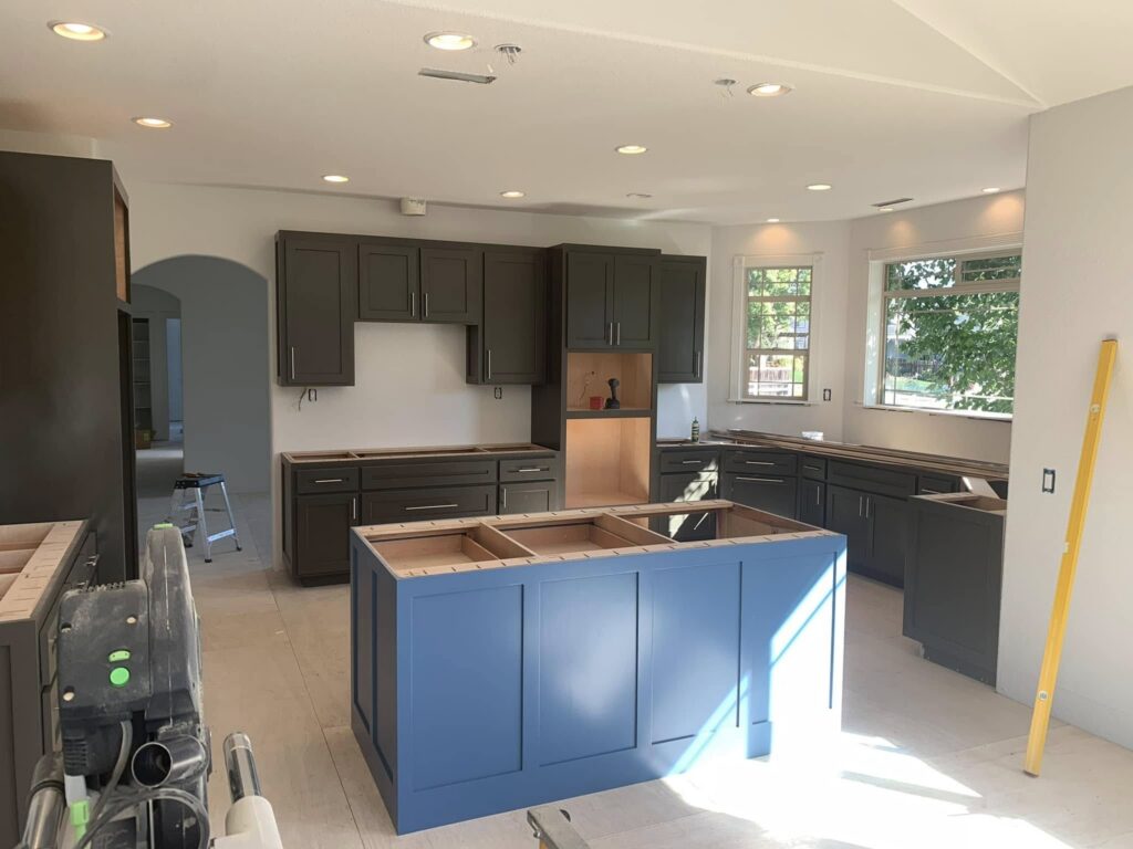 Blue island and gray perimeter cabinets before final completion