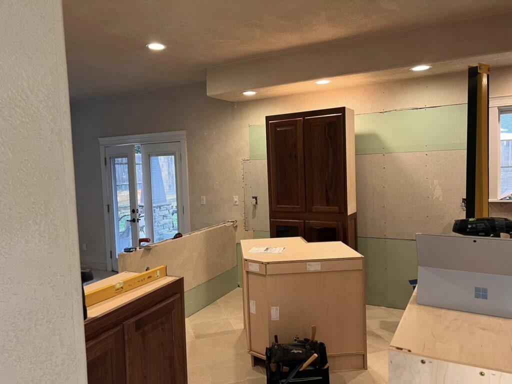 Walnut cabinets and island during installation near a doorway
