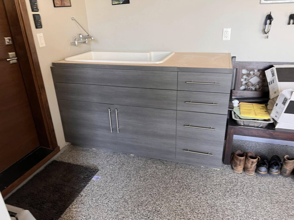 Gray flat-panel cabinet with drawers beside an entry door